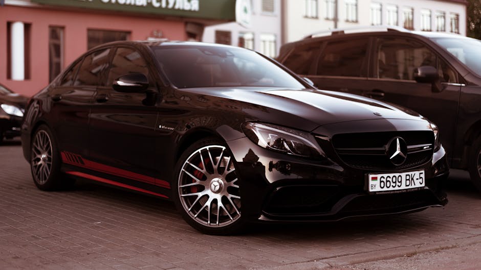 A stylish black Mercedes C-Class vehicle parked on urban pavement, showcasing luxury design