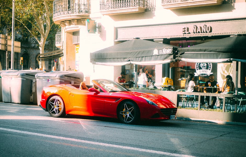 A vibrant red convertible sports car parked outside El Naño cafe in an urban setting